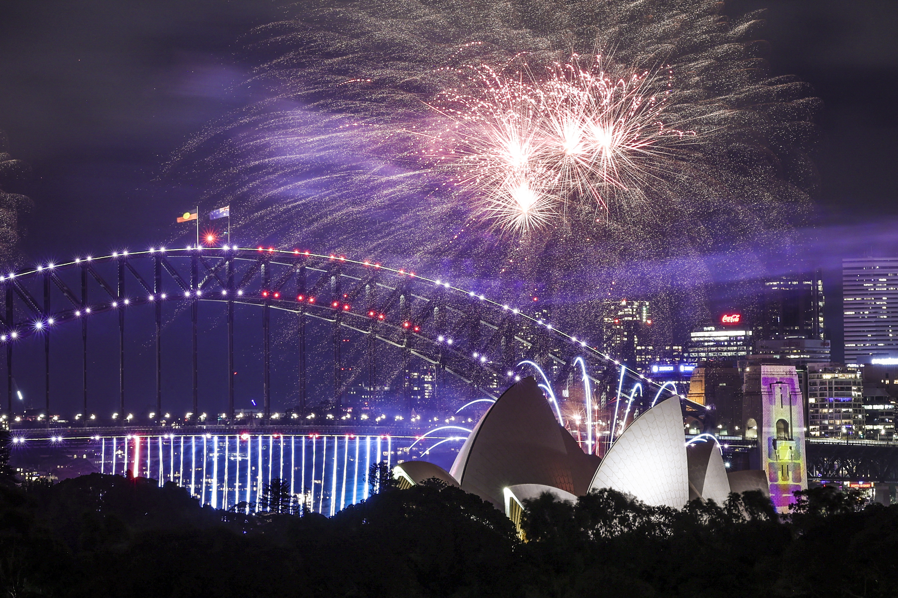 Fuegos artificiales iluminan el cielo de medianoche sobre el Puente del Puerto de Sídney y la Ópera de Sídney durante las celebraciones del Día de Año Nuevo en Sídney el 1 de enero de 2025.
